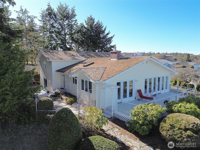 rear view of house featuring french doors and a chimney