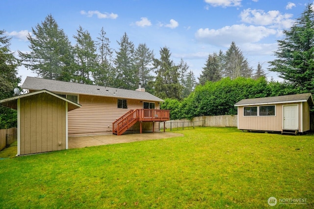 view of yard with a fenced backyard, an outdoor structure, a deck, and stairs