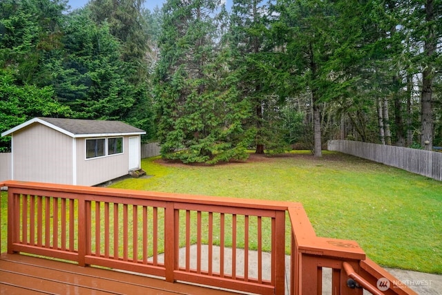 deck with an outbuilding, a fenced backyard, a yard, and a storage unit