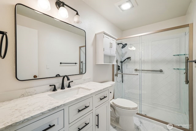 bathroom featuring marble finish floor, a stall shower, vanity, and toilet