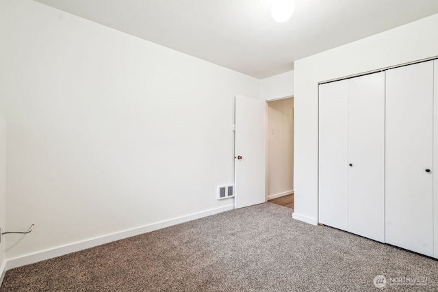 unfurnished bedroom with baseboards, a closet, visible vents, and carpet flooring