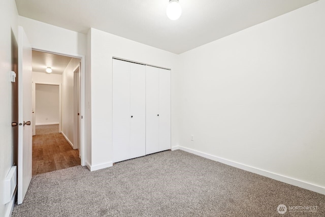 unfurnished bedroom featuring carpet floors, a closet, and baseboards