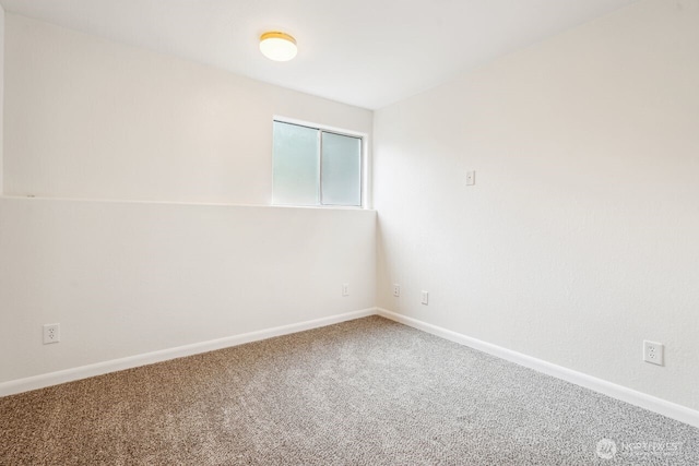 spare room with baseboards and carpet flooring