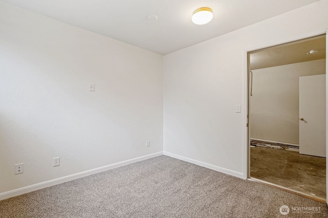 carpeted spare room with baseboards