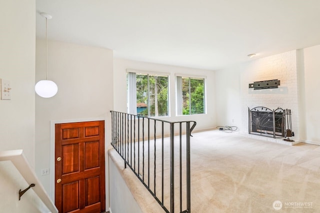 hall featuring carpet flooring, an upstairs landing, and baseboards