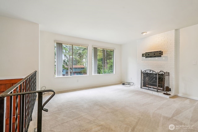 carpeted living room featuring a brick fireplace and baseboards