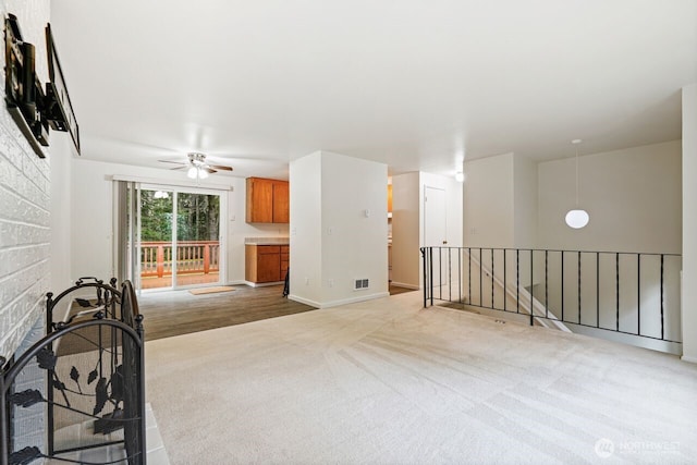 carpeted empty room featuring visible vents, ceiling fan, and baseboards