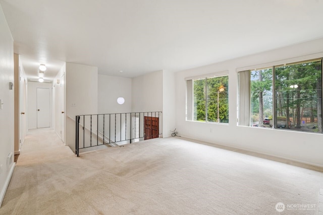 unfurnished room with carpet floors, baseboards, and visible vents