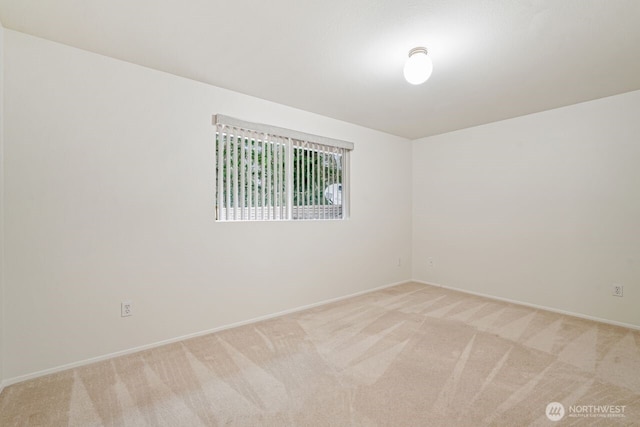 unfurnished room with light carpet and baseboards