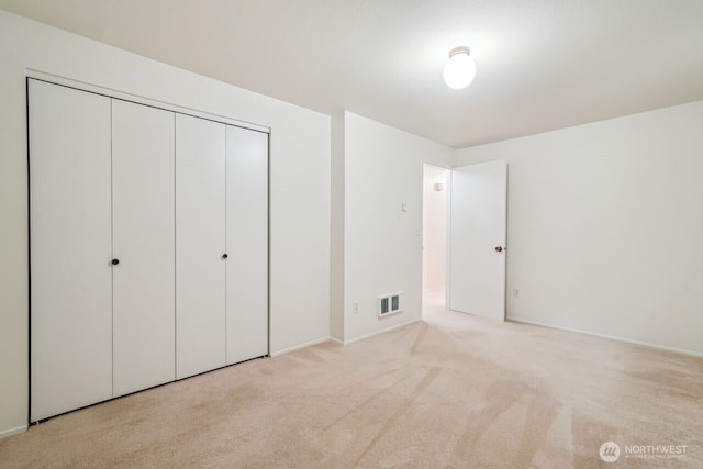 unfurnished bedroom with visible vents, a closet, and carpet flooring