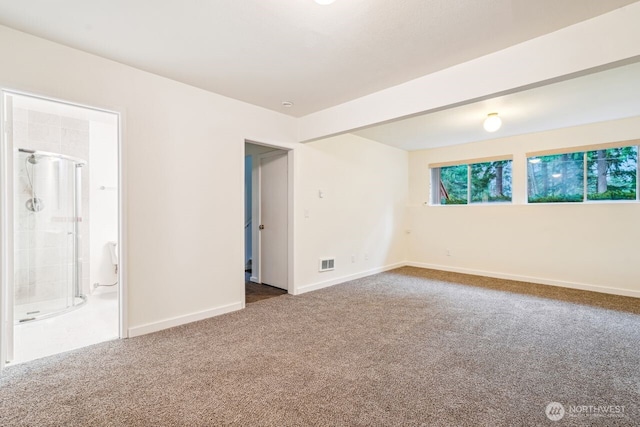 carpeted spare room featuring visible vents and baseboards