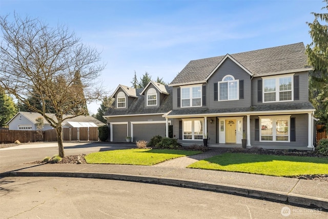 view of front facade featuring driveway, roof with shingles, an attached garage, fence, and a front yard