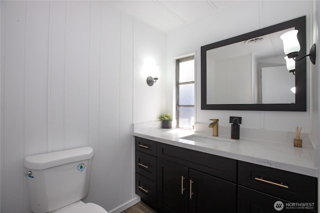 bathroom with toilet, visible vents, and vanity