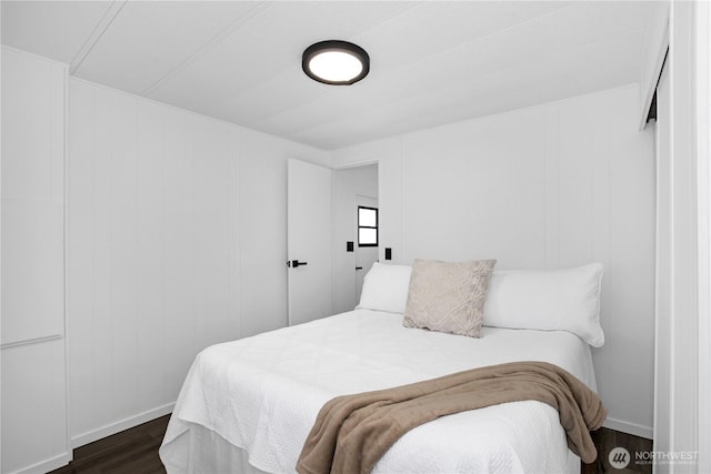 bedroom featuring dark wood-style floors and baseboards