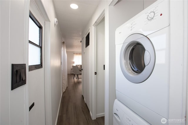 laundry area with recessed lighting, laundry area, dark wood-type flooring, stacked washer / dryer, and baseboards