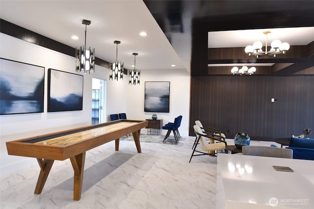 playroom featuring a notable chandelier, marble finish floor, wooden walls, and recessed lighting