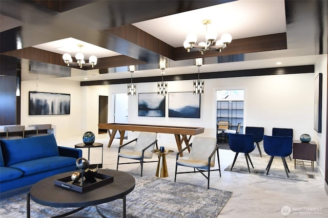 living room with marble finish floor and a notable chandelier