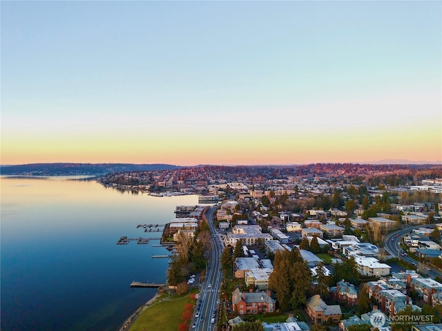 aerial view at dusk featuring a water view