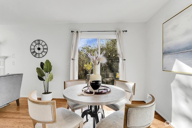 dining area with light wood-style floors and baseboards