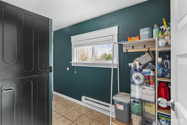 interior space with tile patterned flooring, a baseboard heating unit, and baseboards