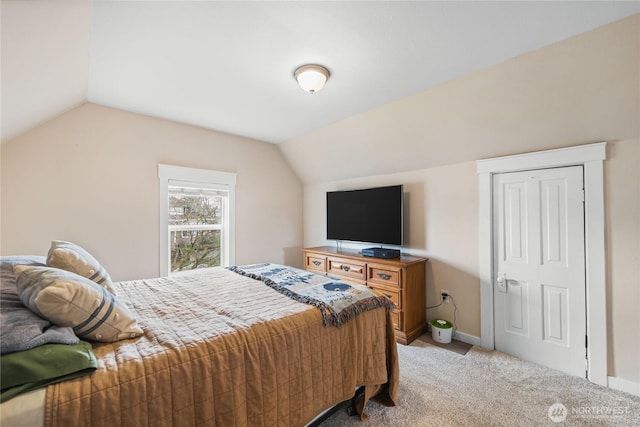 bedroom featuring vaulted ceiling, light colored carpet, and baseboards