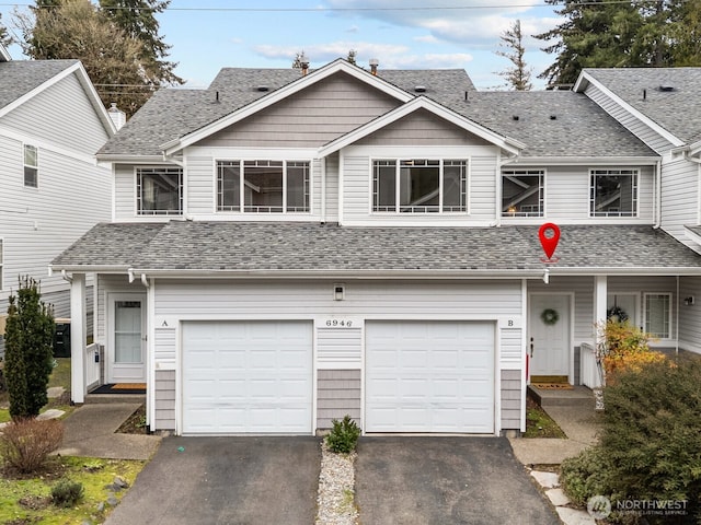 townhome / multi-family property with a garage, driveway, and a shingled roof