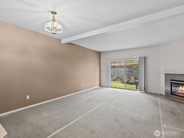 unfurnished living room featuring baseboards, beamed ceiling, carpet flooring, a fireplace, and a notable chandelier