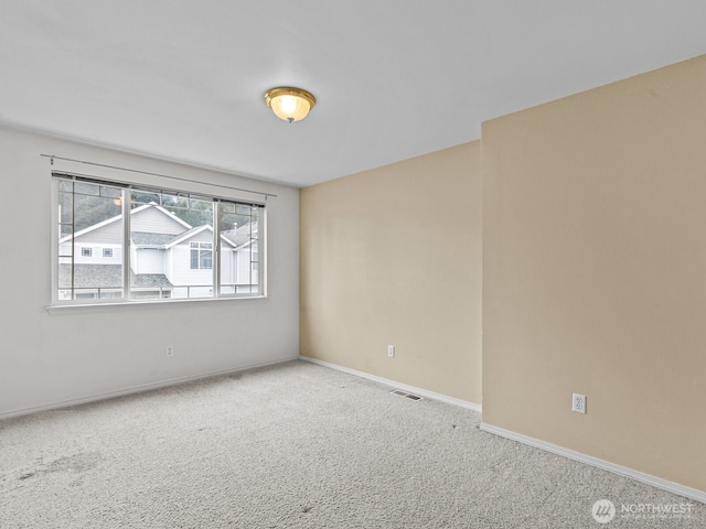 carpeted empty room with visible vents and baseboards