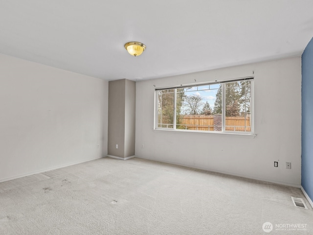 carpeted empty room with visible vents and baseboards