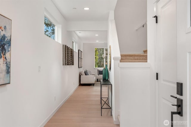 hallway featuring recessed lighting, light wood-type flooring, stairs, and baseboards