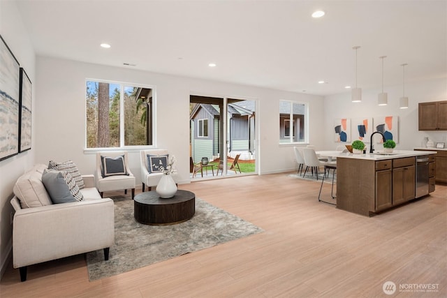 living room with recessed lighting, light wood-type flooring, and baseboards