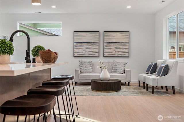 living area with visible vents, recessed lighting, baseboards, and wood finished floors