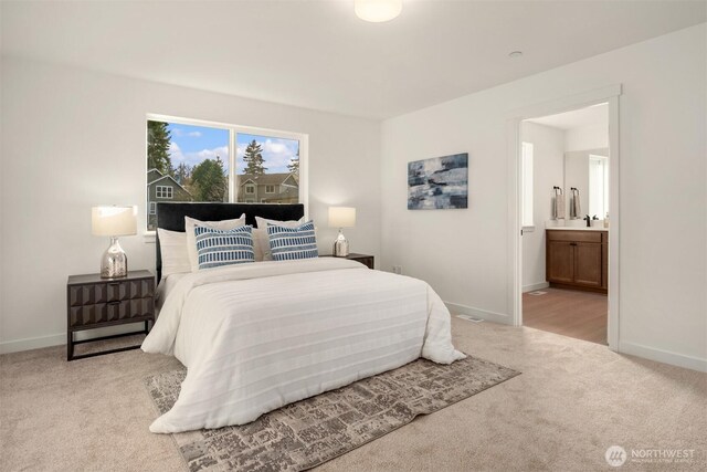 bedroom featuring baseboards, ensuite bath, and carpet flooring