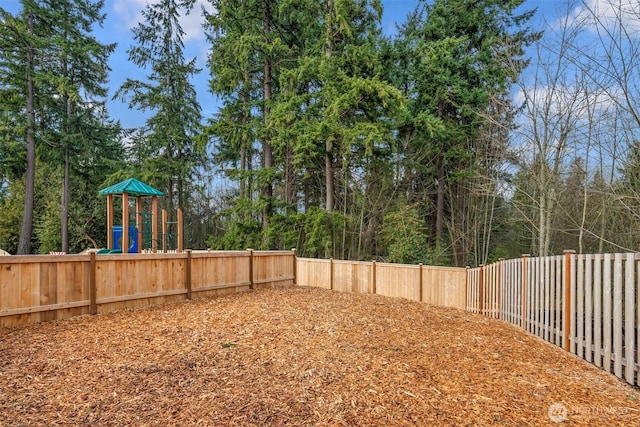 view of yard featuring a playground and a fenced backyard