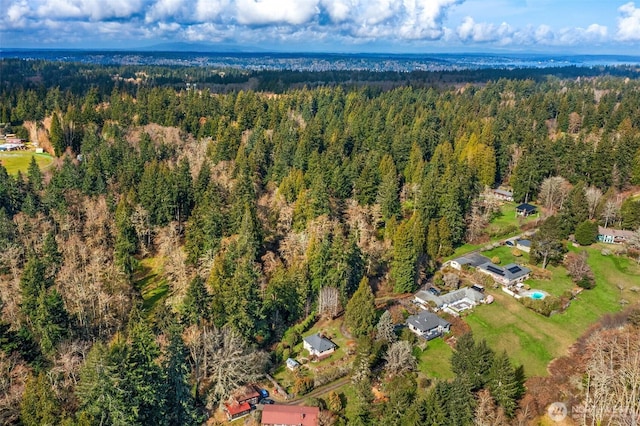 bird's eye view with a wooded view