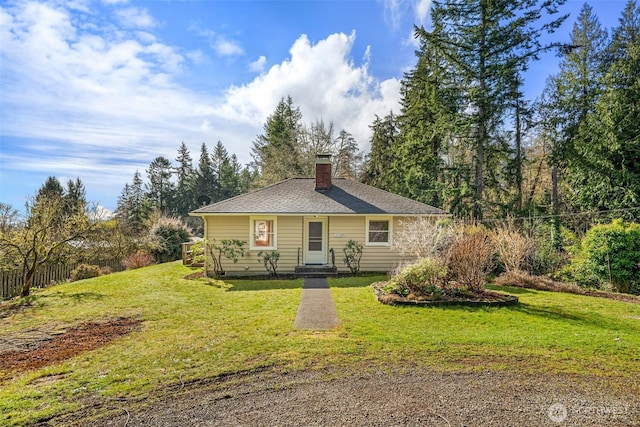 view of front of property featuring a shingled roof, fence, a chimney, and a front lawn