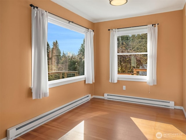 unfurnished room with a baseboard heating unit and crown molding