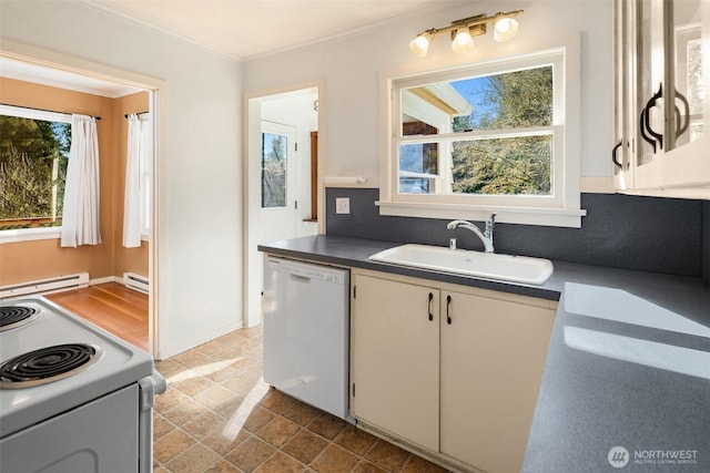 kitchen with dark countertops, white appliances, baseboard heating, and a sink