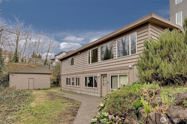 back of property featuring an outdoor structure