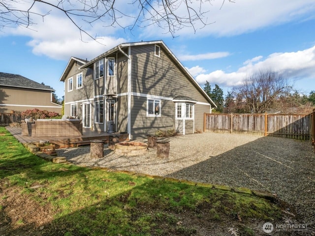 back of house with gravel driveway, a fenced backyard, and a wooden deck