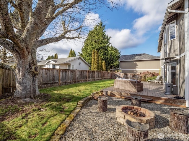 view of yard featuring a fenced backyard, an outdoor fire pit, and a deck