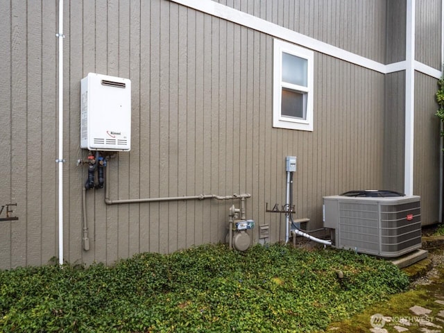 view of home's exterior with tankless water heater and central AC