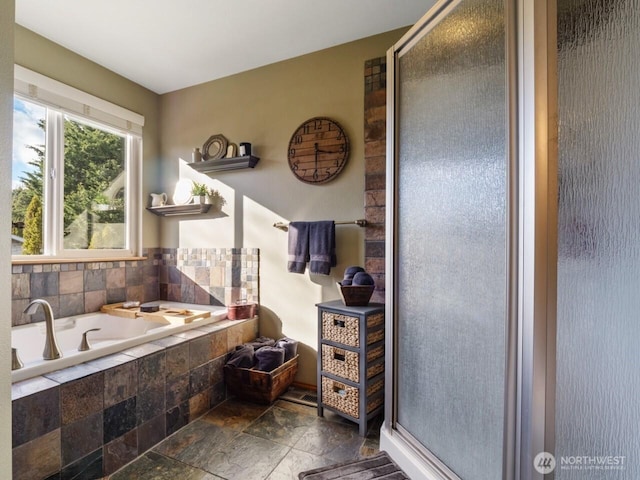 full bath with stone tile floors, a stall shower, and a bath