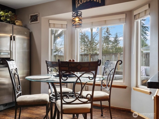 dining area with baseboards and wood finished floors