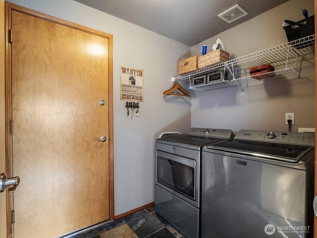 laundry room with stone tile floors, visible vents, baseboards, laundry area, and independent washer and dryer