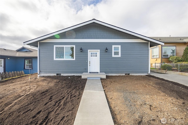 view of front of home with crawl space and fence