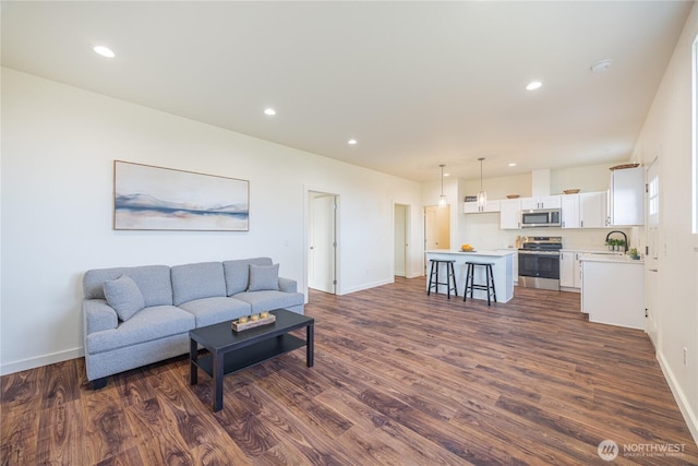 living room with dark wood-type flooring, recessed lighting, and baseboards