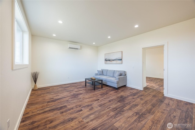 living area with recessed lighting, dark wood-style flooring, a wall mounted air conditioner, and baseboards