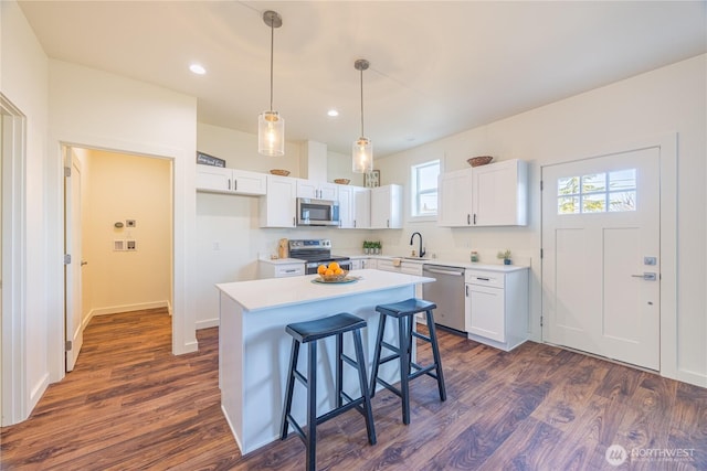 kitchen featuring stainless steel appliances, dark wood finished floors, light countertops, and white cabinets