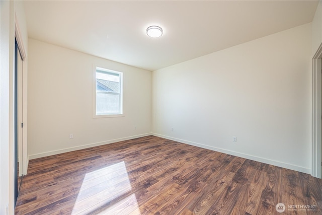 unfurnished bedroom featuring dark wood-style floors, a closet, and baseboards